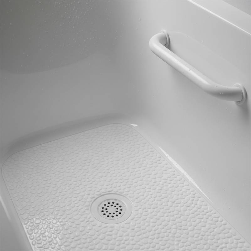 A close-up view of a bathtub's interior showing a textured, non-slip floor and a sturdy integrated safety handle.